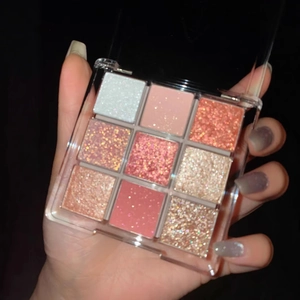 Close-up of a 9-color eyeshadow palette with matte and shimmer pink and gold tones