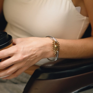 Gros plan détaillé d'un bracelet jonc bicolore argent et or avec l'œil protecteur