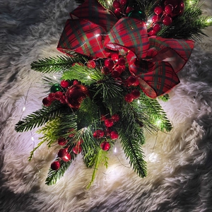 Detail of Christmas teardrop swag with red berries, plaid bow, and warm LED lights