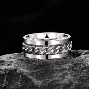 Macro shot of silver spinner ring with rotatable Cuban chain detail on a dark stone