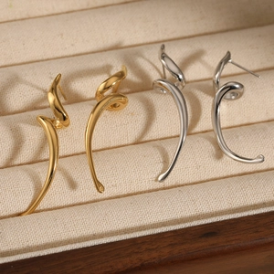 Minimalist spiral twisted earrings set in gold and silver finish on display