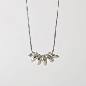 Minimalist silver interlocking multi-ring pendant on a sleek snake chain necklace