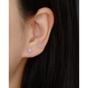 Close-up of s925 silver four-leaf clover stud earrings with purple zircons on model ear