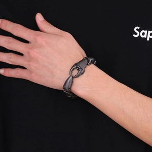 Gros plan du bracelet scorpion en acier inoxydable vintage sur un poignet