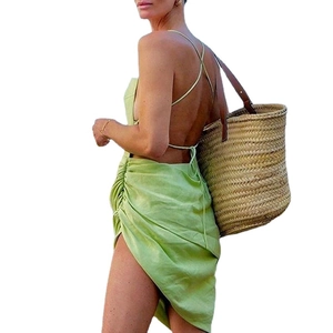 Sexy green backless halter dress with irregular split hem and chic straw tote bag