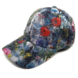Close-up of distressed denim baseball cap with colorful vintage floral and butterfly patterns