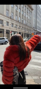 Detail of red faux mink fur coat featuring a luxury segmented design and tiered texture