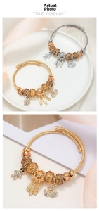 Detail of DIY charm bracelets with teddy bear and swan pendants in gold and silver finish