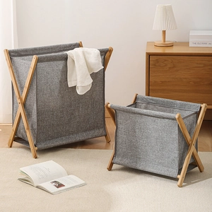 Detail view of foldable bamboo laundry baskets in grey fabric showing the X-shaped wooden frame