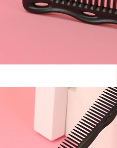 Detail view of professional black hair cutting comb showing dense and wide teeth