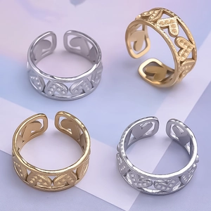 Detailed view of hollow heart pattern on adjustable gold and silver stainless steel rings