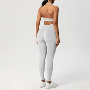 Dettaglio del reggiseno sportivo grigio con schiena scoperta e leggings a vita alta in maglia