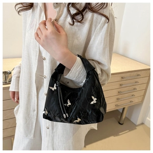 Chic black pleated handbag with silver butterfly studs and unique textured finish