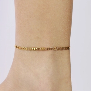 Macro shot of a golden marina chain anklet worn on ankle with high metal luster