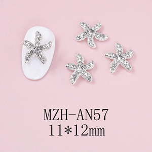 Close-up of 11x12mm silver starfish nail charms with rhinestones on pink background