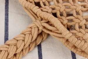 Close-up of woven beige cotton rope bag showing detailed mesh texture and sturdy handle knots