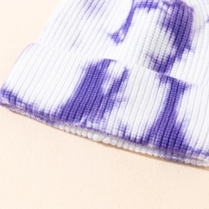 Detail des lila Batikmusters auf einer gerippten Strickmütze mit weicher Textur