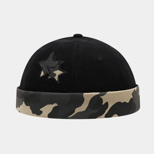 Detail of black docker hat featuring camo star embroidery and a rolled camouflage brim