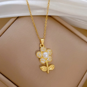 Elegant gold flower necklace with white pearl and micro-diamonds on a jewelry box