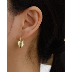 Close-up of elegant gold twisted hoop earrings worn by a model for a stylish look