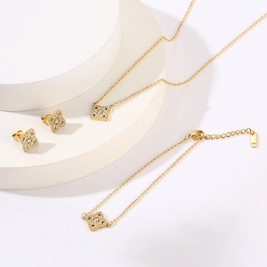 Golden titanium steel four-leaf clover jewelry set with necklace, bracelet, and earrings