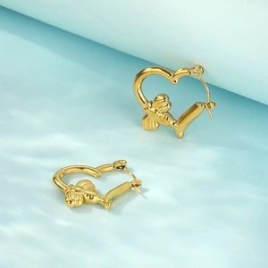 Golden heart-shaped stainless steel earrings with 3D bee design on light blue background