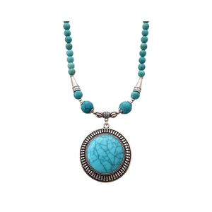 Vintage bohemian turquoise beaded necklace with a large round pendant and silver floral accents