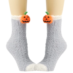 Nahaufnahme grauer Korallenvlies-Socken mit dekorativer 3D-Kürbis-Plüschfigur