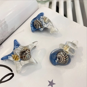 Détail des barrettes étoiles de mer et dauphins avec perles et textures en résine