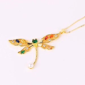 Detail of dragonfly pendant necklace with colorful crystals and a white pearl drop