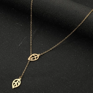 Golden Y-shaped sweater necklace with hollow leaf pendants on black textured surface