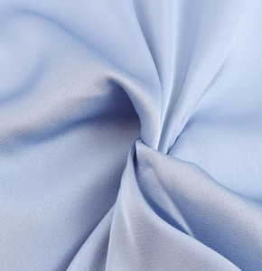 Macro shot of light blue satin fabric with elegant drape and silky smooth texture details