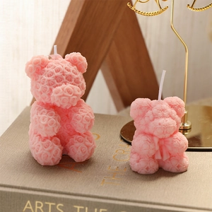 Pink rose bear shaped scented candles in two sizes placed on a book for home decor