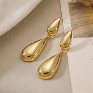 Detailed macro view of 18K gold-plated double-layer water drop tassel earrings on silk