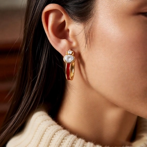 Close-up of 18k gold plated gourd earrings with red enamel and sparkling zircons