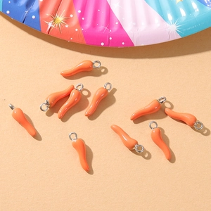 Macro detail of vibrant orange chili pepper alloy pendants for DIY jewelry making and crafts