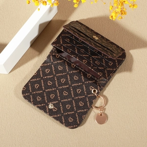 Brown monogram foldable wallet with heart print and gold keychain on a textured background