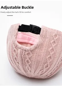 Detail of pink knit baseball cap with adjustable black buckle and nylon strap closure