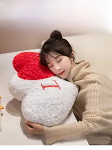 Macro detail of plush heart pillow with embroidered letter and soft sherpa texture