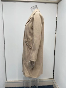 Side view detail of a beige mid-length wool coat with classic lapels and side pockets