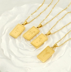 Macro shot of 18K gold plated stainless steel zodiac pendants on white floral tray