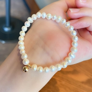 Detail of natural freshwater pearl bracelet with 14K gold-filled bead on female wrist