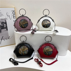 Elegant retro shell bags with elephant embossing in four colors on a white geometric stand