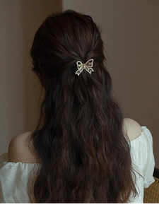Close-up of golden butterfly hair claw clip with rhinestones on a woman's hair