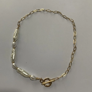 Detail of baroque pearls joined with a golden metal chain and a toggle clasp closure
