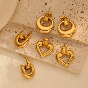 Vintage heart and geometric gold titanium earrings set on elegant beige stone