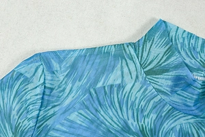 Close-up of high neck mesh dress with tropical feather print and sheer fabric texture