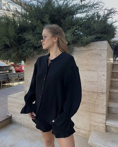 Détail de l'ensemble chemise noire à manches longues en tissu gaufré et coupe ample