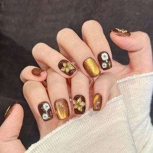 Brown and gold cat-eye press-on nails with 3D flower embossing and retro textures