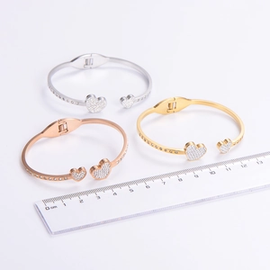 Three open heart bracelets in rose gold, gold, and silver finishes with crystal pavé accents